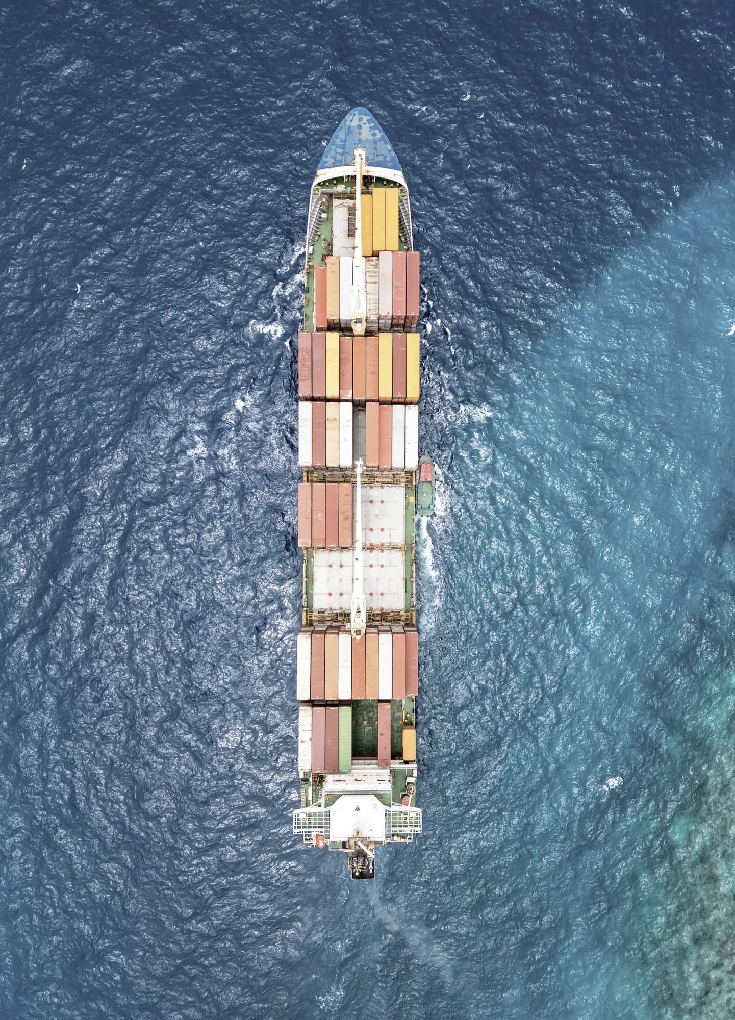 A container vessel seen directly from above, underway at sea.